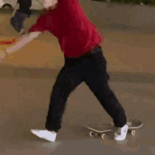 a man in a red shirt is doing a handstand on the street
