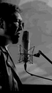 a man singing into a microphone in a black and white image