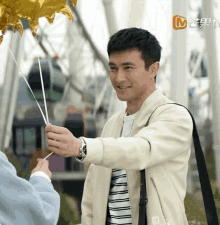 a man is holding a balloon in front of a ferris wheel