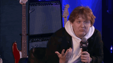 a man talking into a microphone with a cbs logo on it