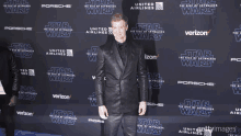 a man in a suit is standing in front of a star wars advertisement