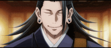a man with long black hair and ear piercings is smiling