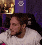 a man wearing a white shirt that says pwk on it
