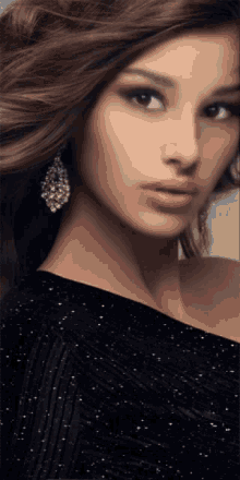 a close up of a woman 's face wearing a black dress and earrings