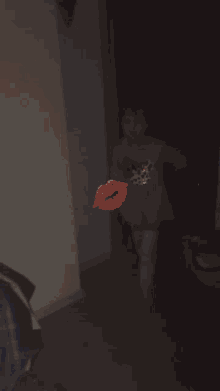 a little girl in a pink dress is dancing with a red kiss behind her