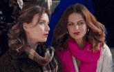 two women are sitting next to each other wearing scarves and earrings
