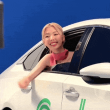 a woman is sitting in a white car with the number 6 on the side