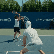 two tennis players on a court with jpmorgan written on the back wall