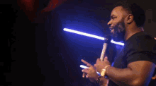 a man in a purple shirt is holding a microphone in front of him