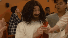 a man dressed as jesus is giving a high five to someone