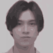 a close up of a young man 's face with long hair .