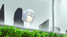a girl with white hair is sitting in front of a computer screen that says ' a ' on it