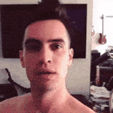a man without a shirt is standing in front of a tv