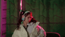 a woman wearing headphones with pigtails on her hair is making a funny face .
