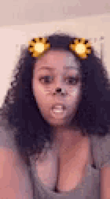 a woman with curly hair and a lion face mask on her face .