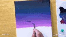 a person is painting on a canvas with a made in animatica logo in the corner