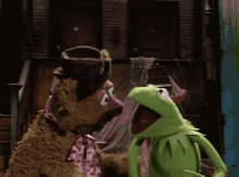 kermit the frog is standing next to mrs. sesame street bear
