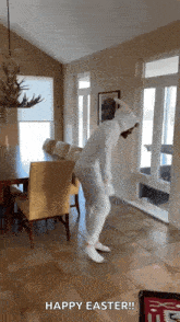 a person in a bunny costume is dancing in a room with the words happy easter written on the floor