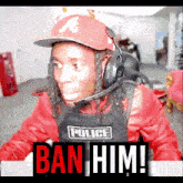 a man wearing a hat and headphones with a police vest that says ban him on it