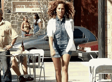 a woman dancing in front of a sign that says clinica