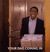 a man in a suit is carrying a stack of pizza boxes in a doorway .