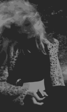 a black and white photo of a woman in a leopard print jacket .
