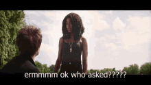 a woman in a black tank top is talking to a man in a black shirt and says ermmmm ok who asked