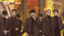 a group of men standing on a stage with a sign that says 15 mbc music live on it