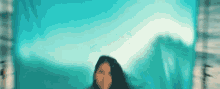a woman is standing in front of a blue background .