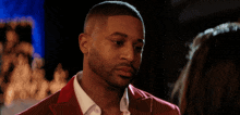a man in a red suit is looking at a woman