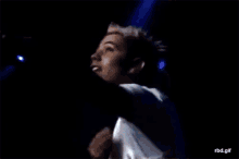 a man singing into a microphone on a stage with the word nb gif visible in the corner