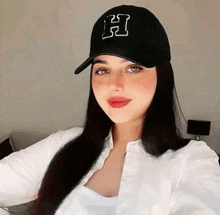a woman is wearing a black hat with the letter h on it