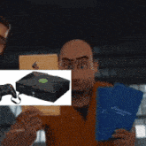 a man holding a picture of an xbox with a controller