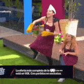 two women wearing aprons and chef hats are dancing in front of a sign that says la oferta mas completa de la liga mx