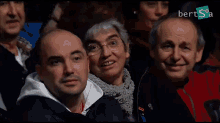 a group of people sitting in front of a sign that says bert sa