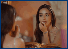 a woman is looking at herself in the mirror