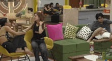 a group of people are sitting on a couch and one of them is wearing a black shirt that says bang