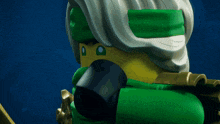 a close up of a green lego figure with a beard