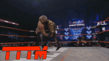 a wrestling match is taking place in front of a bullet club banner
