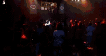 a group of people are sitting in a crowd at a concert .