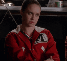a woman wearing a red varsity jacket with the letter m on it