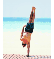 a man is doing a handstand on a beach