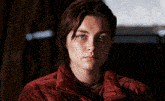 a woman is wearing a red jacket and looking at the camera