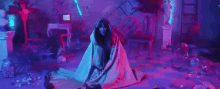 a woman is laying on the floor wrapped in a blanket in a messy room .
