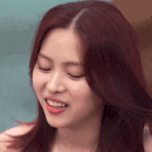a close up of a woman with red hair smiling .