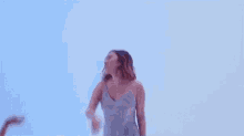 a woman in a blue dress is dancing with a little girl in a blue room .