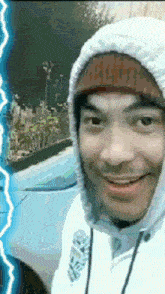 a man wearing a hooded sweatshirt and a beanie with the letter r on it