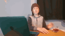 a boy sitting in front of a hp laptop