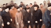 a group of men are standing in a room dancing together .