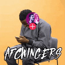 a man sits in a chair looking at his phone and the words afcwingers are visible
